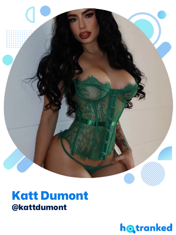 Katt Dumont in green lace corset posing indoors